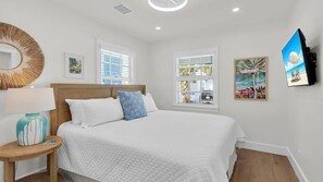 A bedroom with a bed, a bedside table with a lamp, and a wall-mounted TV. - **PALMS ON DUVAL @ OLD TOWN** Private Home w/ Pool + LAST KEY SERVICES... (Key West)