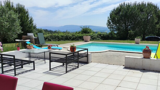 A poolside area with a pool, seating, and potted plants. - Detached house, fully fenced, swimming pool, bowling green, dogs welcome. (La Bezole)