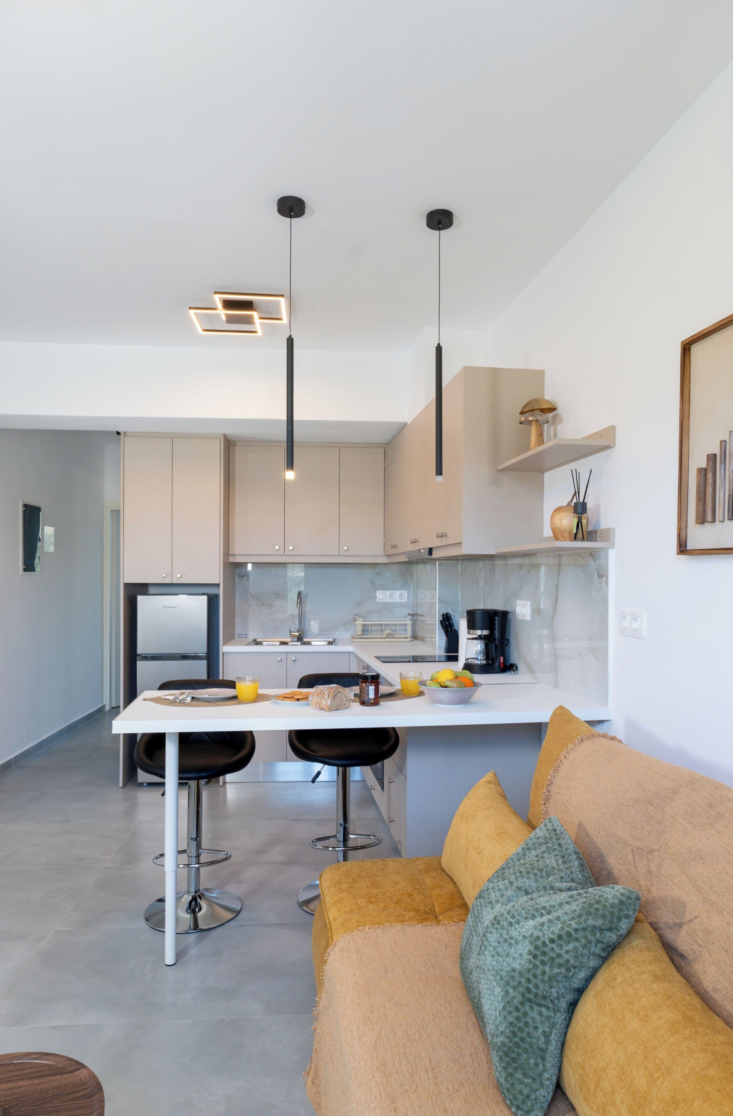 Cozinha moderna com ilha central, banquetas e iluminação pendente.