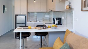 Een moderne keuken met een centraal eiland, barstoelen en hanglampen.