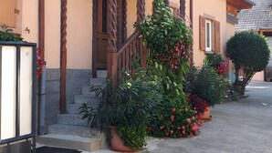 Un edificio con un balcón de madera, plantas en macetas y una puerta.