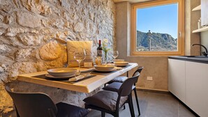 A stone wall, a dining table with plates and glasses, and a view of a mountain through a window. - Chalet 'Al Volt' with Mountain View, Private Terrace and Garden (Voiandes)