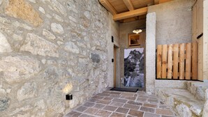 A stone-walled corridor with a wooden door and a view of a mountain. - Chalet 'Al Volt' with Mountain View, Private Terrace and Garden (Voiandes)