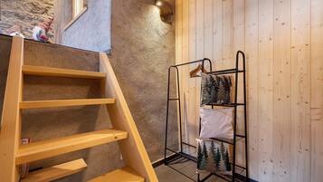 A wooden staircase, a metal rack with decorative items, and a textured wall.