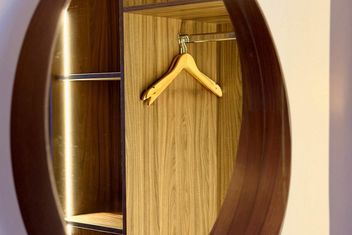 A circular wooden wardrobe with a hanging hook.