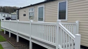 A single-story mobile home with a white exterior and a white porch railing. - Caravan- Sleeps 6, 2 Bedrooms - Thurston Manor (Dunbar)