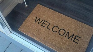 A welcome mat with the word "WELCOME" on a wooden door. - Caravan- Sleeps 6, 2 Bedrooms - Thurston Manor (Dunbar)