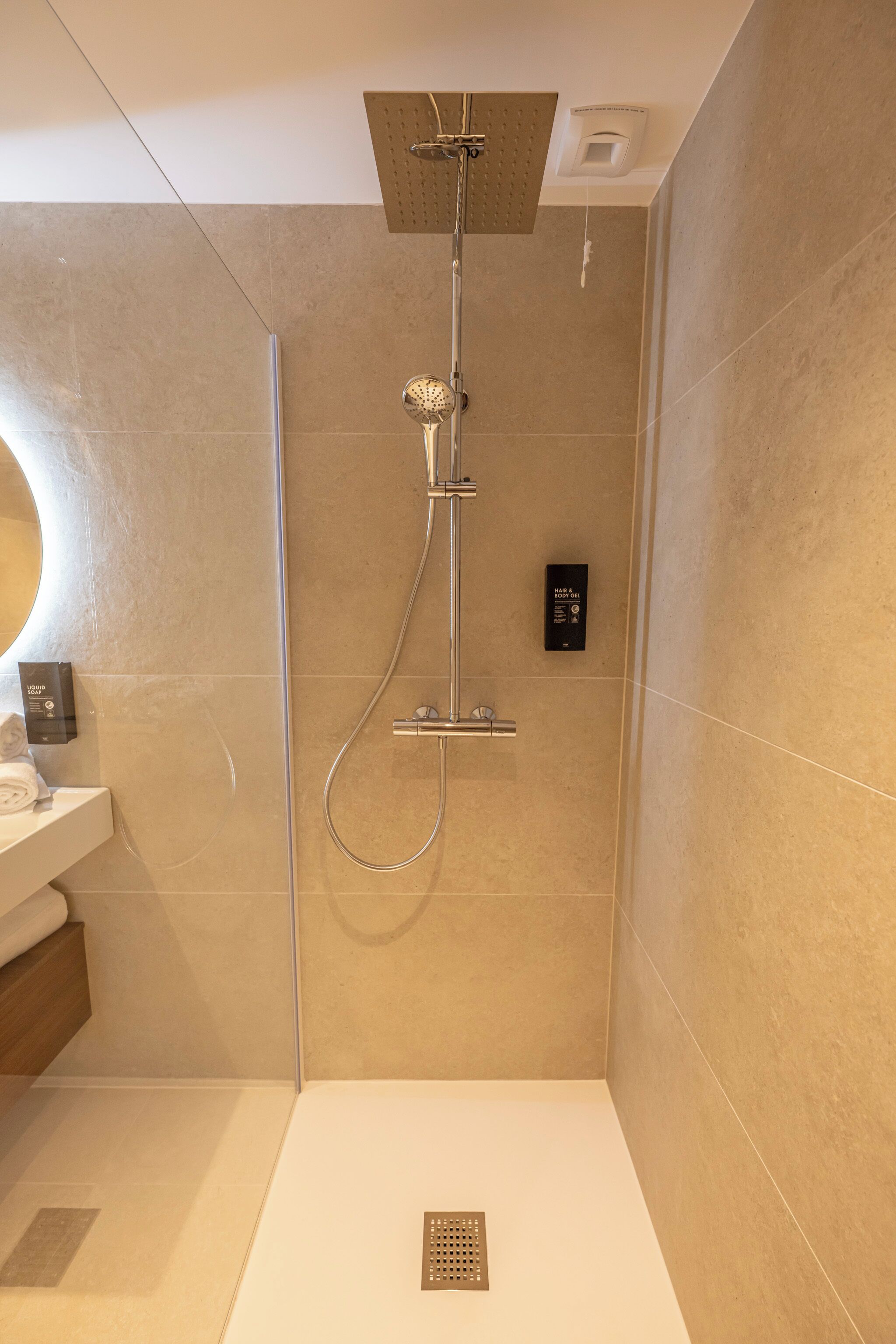 Un baño moderno con ducha, inodoro y lavabo.