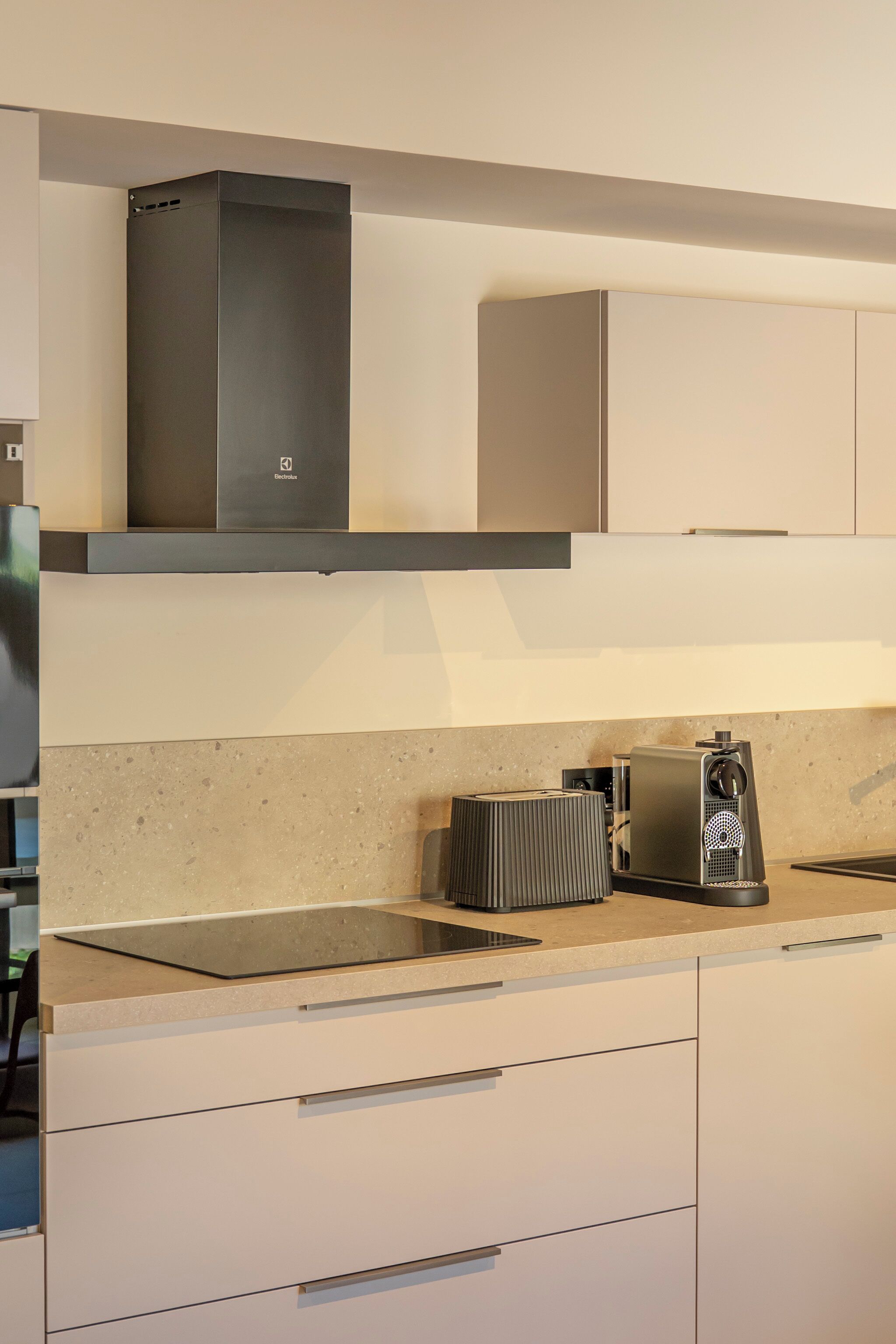 Una cocina moderna con cafetera integrada y extractor de humos.