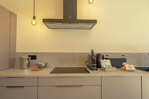 A modern kitchen with a built-in stove, a coffee machine, and a kettle. - SAN PETRU (Porto-Vecchio)