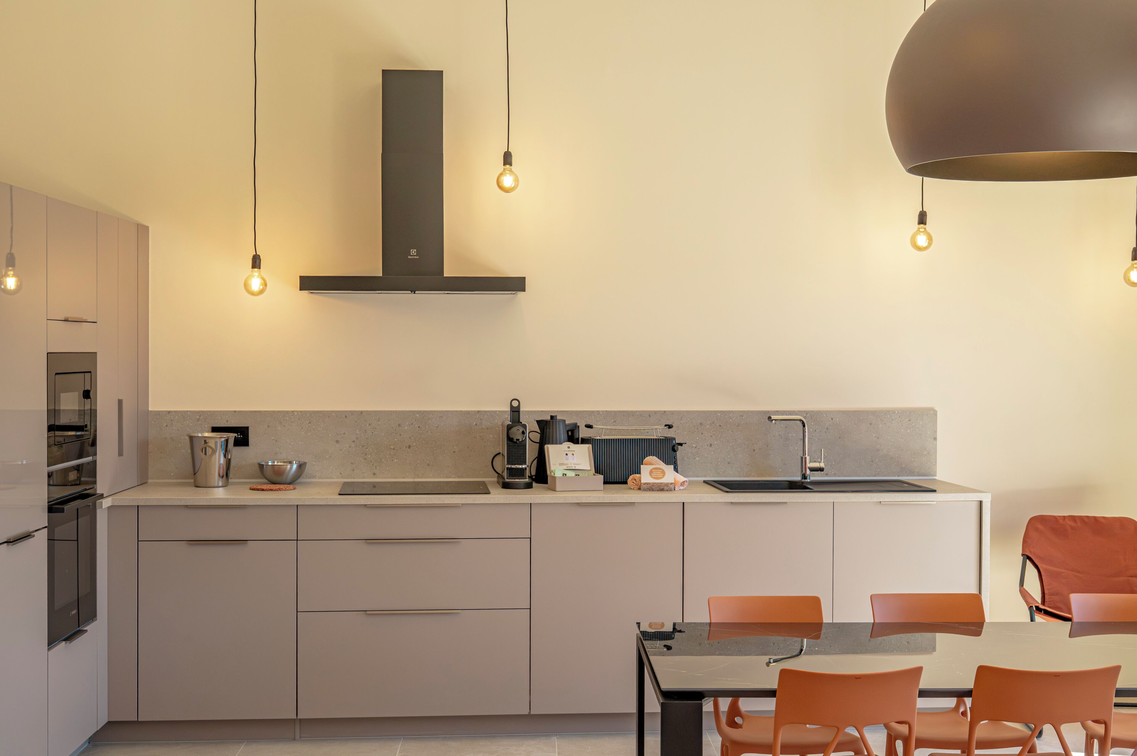A modern kitchen with a central island, stainless steel appliances, and pendant lighting.