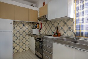A kitchen with a stove, oven, microwave, and sink.