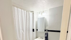 Ein kleines Badezimmer mit Badewanne, Waschbecken und Toilette.