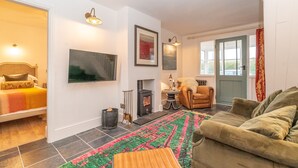 Una sala de estar acogedora con un sofá, una chimenea y una cama.
