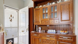 Una cocina de madera con armarios, una puerta para mascotas y una encimera con utensilios de cocina.