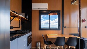 A modern kitchen with a gas stove, oven, and a window with a view of the sky. - Cabin With Panoramic View of the Sierra Vst043 (Anitapolis)