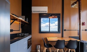 A compact kitchen with a gas stove, oven, and a window with a view of the sky.