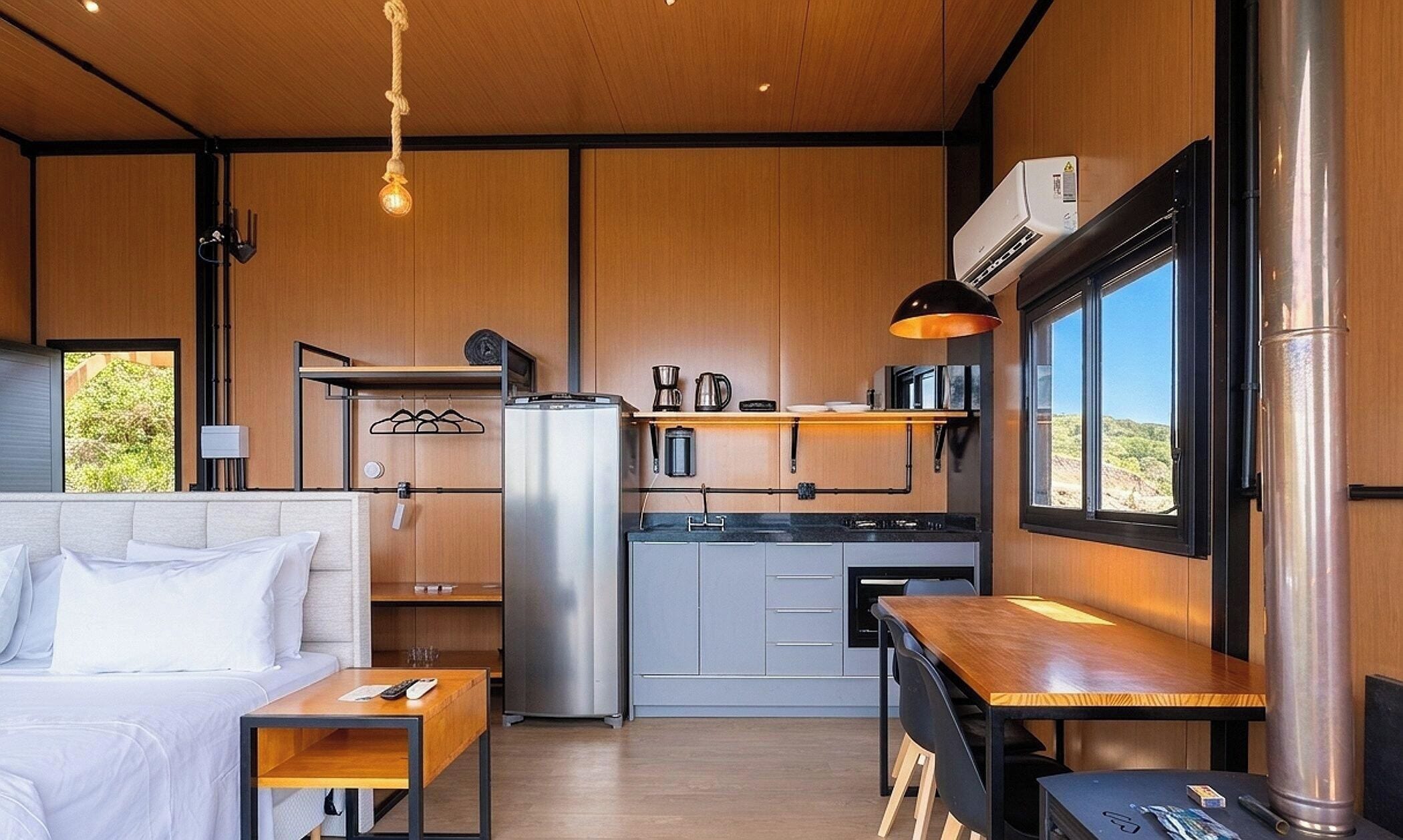Un espacio habitable pequeño con kitchenette, una cama y zona de comedor.