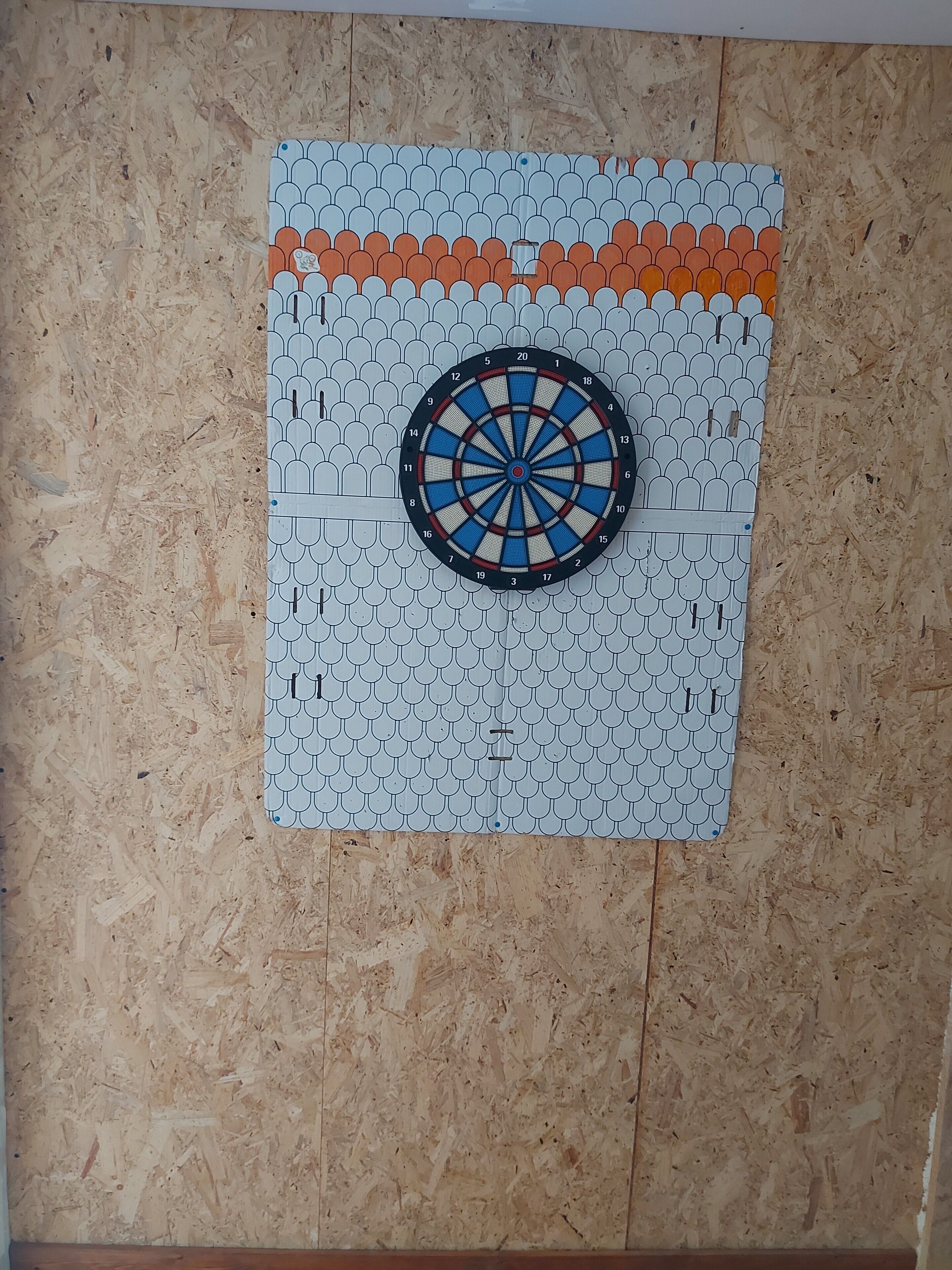 Dartbord bevestigd aan een muur met een gedessineerde achtergrond.