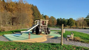 A playground with a slide, a wooden structure, and a bench. - Cozy House for 4 in the Heart of the French Ardennes – Laundry, Bike Storage, Near Rocroi & Belgium (Gué-d'Hossus)