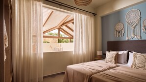 A bedroom with a bed, curtains, a wall with dreamcatchers, and a hanging light fixture.