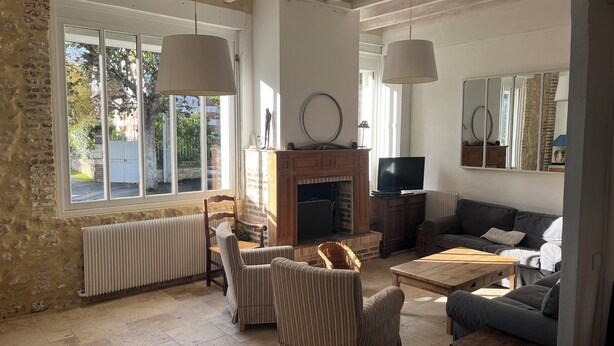 Ein Wohnzimmer mit Kamin, zwei Sofas, einem Couchtisch und einem Fernseher.