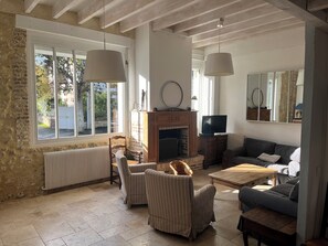 A living room with a fireplace, two sofas, a coffee table, and a TV. - In the center of Cabourg: La Mirabelle "Maison Familiale (Cabourg)