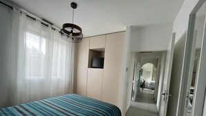 Ein Schlafzimmer mit einem Bett, einem Fernseher und einem Kleiderschrank.