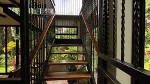A wooden staircase with a metal railing leading to a covered outdoor area. - Full lodging, lookout point  (Mirador)