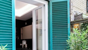 A kitchen with a sliding glass door leading to a balcony. - House Of Victories (Roma)