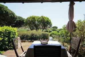 An outdoor dining area with a table, chairs, and a view of the surrounding landscape.