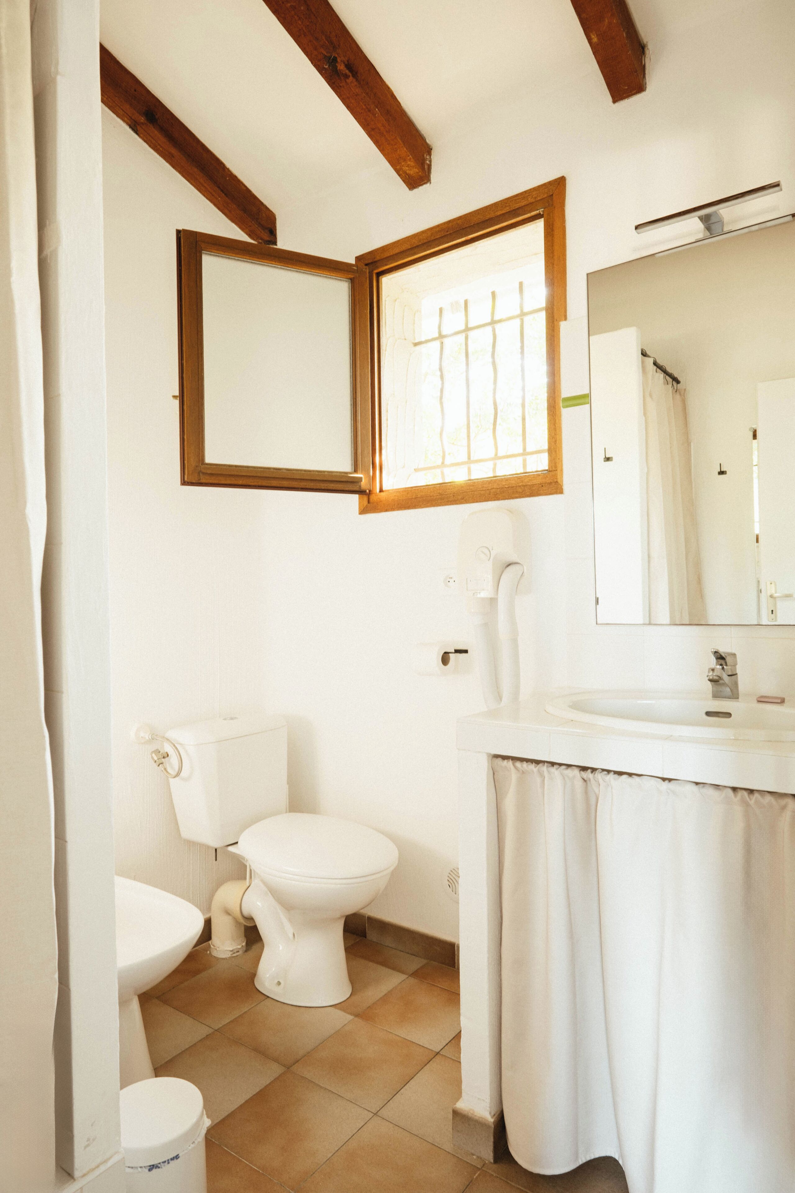 Un baño con inodoro, bidé y lavamanos.
