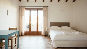 A bedroom with a bed, a table, and a chair. - Résidence Les Hauts de Santa Giulia (Porto-Vecchio)
