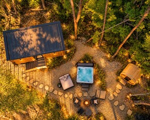 Ein Whirlpool, umgeben von Steinsitzen und einer Holzbeschreibung mit dunklem Dach.