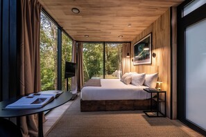 Une chambre avec un grand lit, un bureau et une télévision.