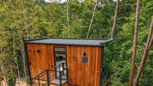Une cabane en bois dotée d’un bain à remous, d’un espace salon extérieur et d’un coin barbecue.