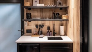 Une cuisine moderne avec des meubles en bois, un réfrigérateur encastré et un plan de travail doté d’un évier.
