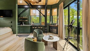 Un interno moderno con cucina, zona pranzo e un telescopio su un balcone.