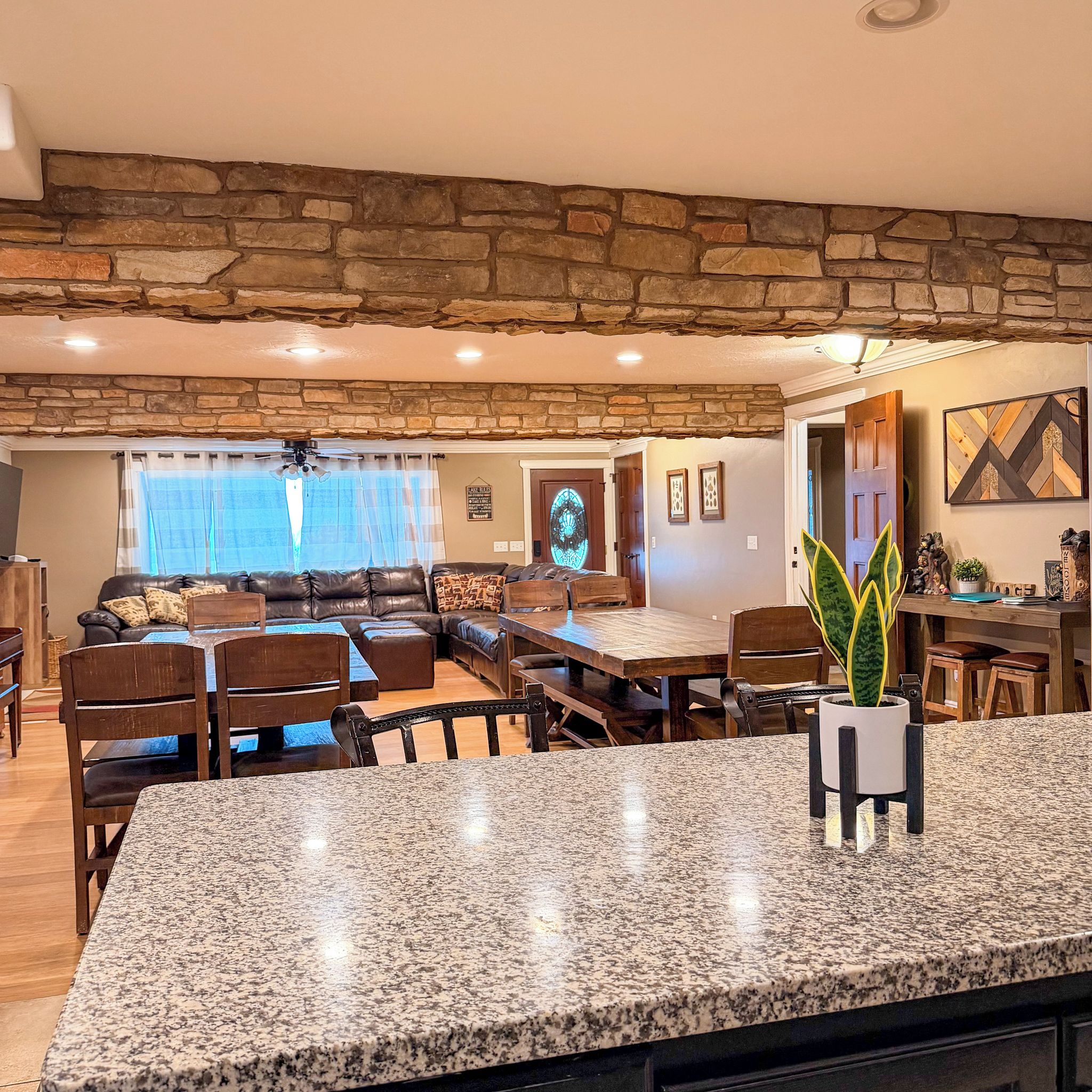 A spacious living area with a stone ceiling, a dining table, and a kitchen area with granite countertops.