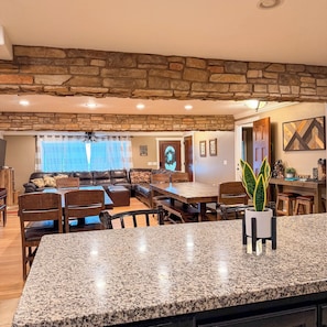 A spacious living area with a stone ceiling, a dining table, and a kitchen area with granite countertops.