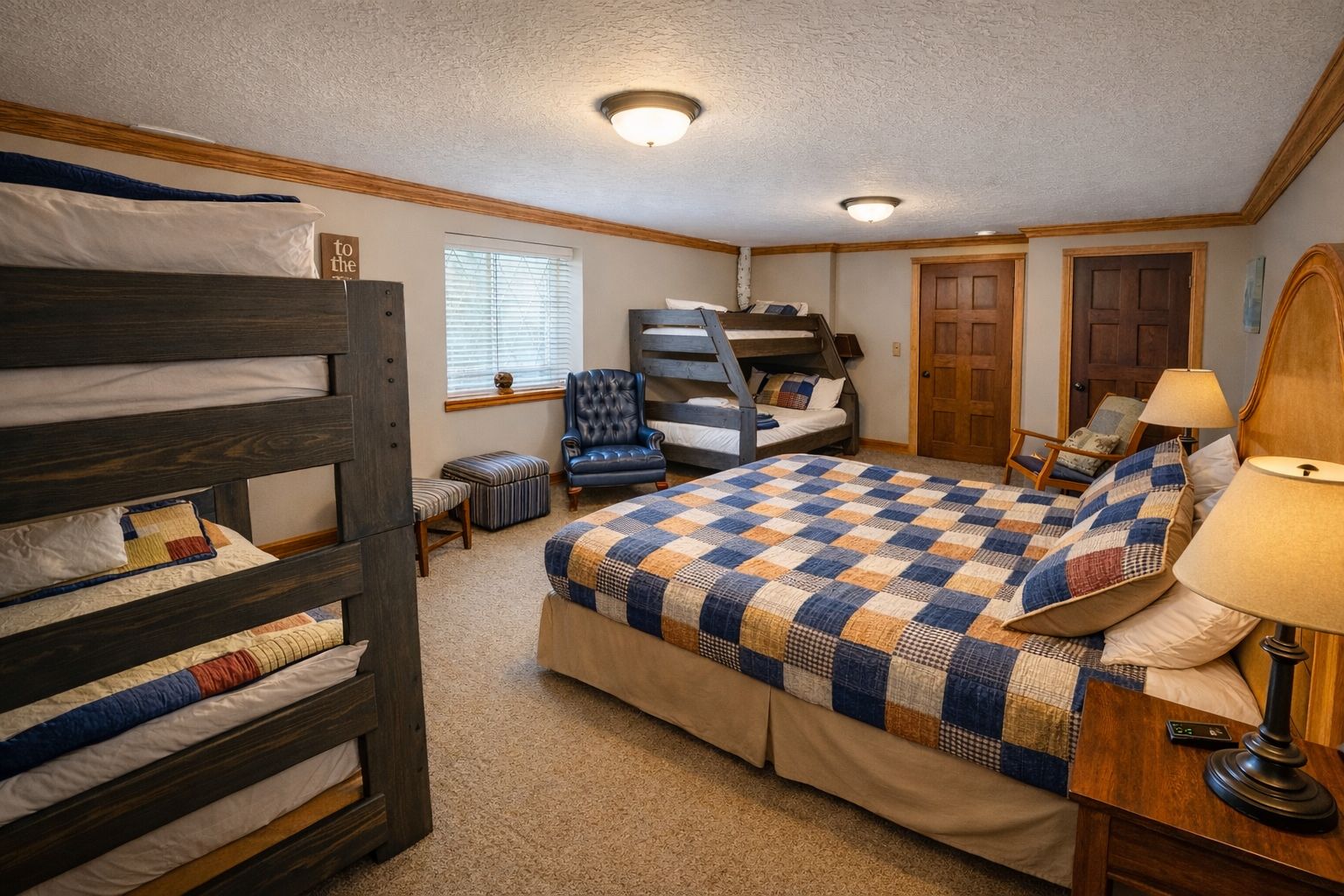 A bedroom with bunk beds, a desk, and a chair.