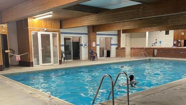 An indoor swimming pool with a wooden ceiling and a tiled floor. - Moorville Hall Hotel (Stoke-on-Trent)