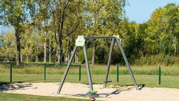 A playground with a swing set and a seesaw.