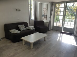 Un salon avec un canapé, un fauteuil et une table basse.