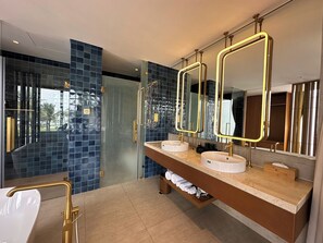 A modern bathroom with two sinks, gold fixtures, and large mirrors. - Wyndham Hoi An Royal Beachfront Resort (Hoi An)