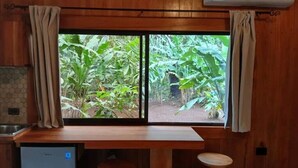 A wooden room with a window overlooking a garden. - Monkey House (Mirador)