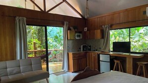 A modern room with a bed, a sofa, a kitchenette, and large windows overlooking greenery. - Monkey House (Mirador)