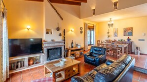 Ein gemütliches Wohnzimmer mit Kamin, Ledersofa und Fernseher.