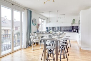 Une cuisine moderne dotée d’un grand îlot central, de tabourets de bar et offrant une vue sur l’extérieur.