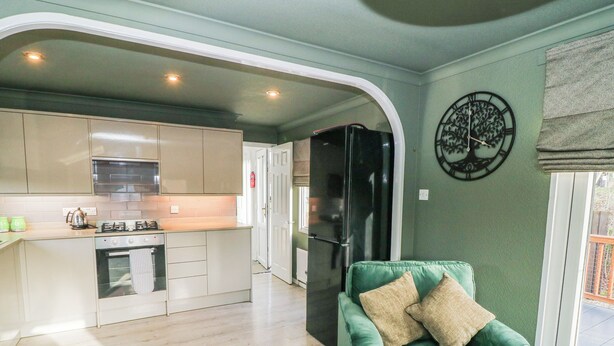 Una cucina moderna con un divano verde nella zona giorno.